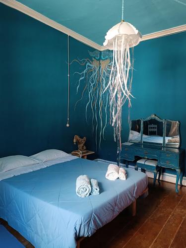 a blue bedroom with a bed with aopus painting on the wall at Avó da Rosa 2 in Faial da Terra