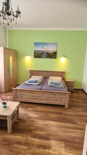 Ferienwohnung في Glindow: غرفة نوم بسرير كبير وجدران خضراء