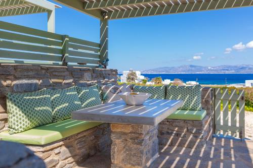 a table and chairs on a patio with the ocean in the background at Supreme Villa with Sea View and Pool in Kampos Paros