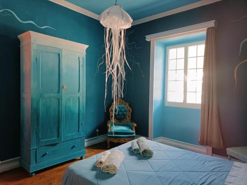 a blue bedroom with a bed and a window at Avó da Rosa 2 in Faial da Terra