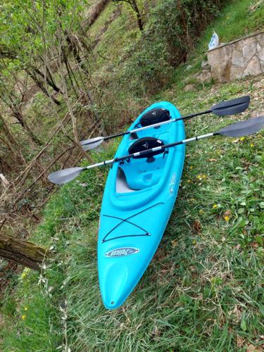 a blue kayak sitting on the grass on a hill at "Kod dva kestena"Warm and cozy house with lake view sauna in Međuvršje
