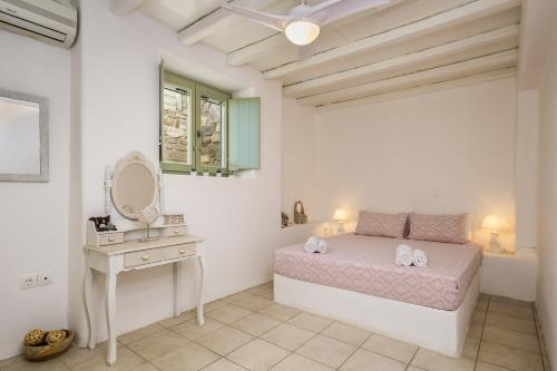 a bedroom with a bed and a vanity and a mirror at Supreme Villa with Sea View and Pool in Kampos Paros