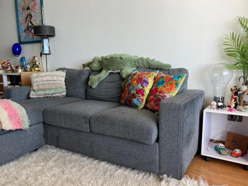 a gray couch with a stuffed teddy bear on it at Departamento Eurocosta Primera Linea in Concón