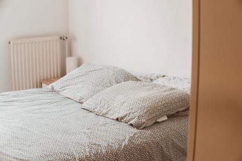 Un dormitorio con una cama con almohadas. en Bel appartement au calme avec parking en Lyon