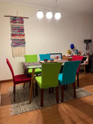 a dining room with a table with colorful chairs at Departamento Eurocosta Primera Linea in Concón