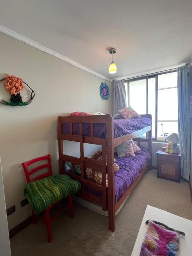 a bedroom with a bunk bed and a chair at Departamento Eurocosta Primera Linea in Concón