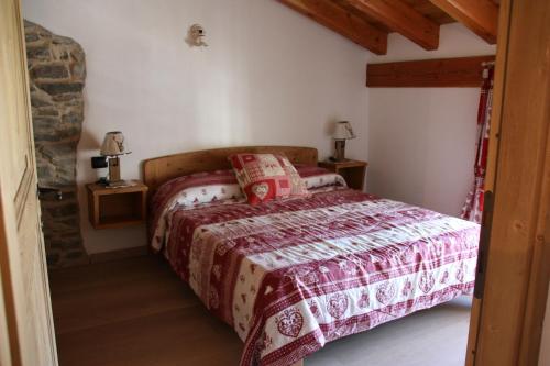 a bedroom with a bed with a red comforter at Lo Trapei in Aosta