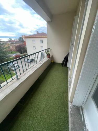 - un balcon avec de l'herbe verte sur le côté du bâtiment dans l'établissement Appartement 2 chambres / parking, à Agen