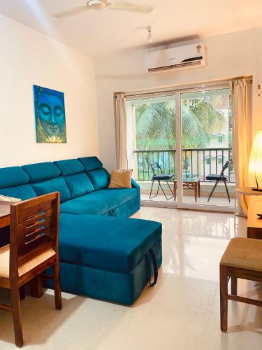 a living room with a blue couch and a table at Luxury apartment Blue lagoon in Goa