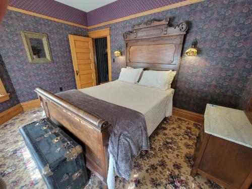 um quarto com uma cama num quarto com paredes roxas em The Weis Mansion Bed and Breakfast em Waterloo