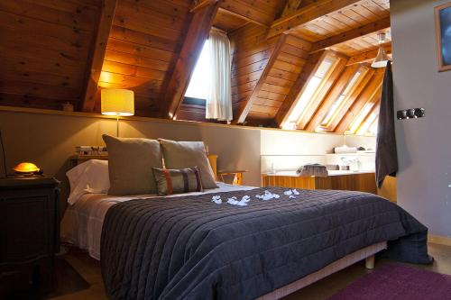 ein Schlafzimmer mit einem Bett in einem Zimmer mit Holzdecken in der Unterkunft Casa Lola Pirene in Vielha e Mijaran