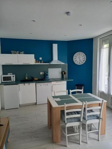 une cuisine avec une table et une horloge au mur dans l'établissement Villa la Brise , Appartement 