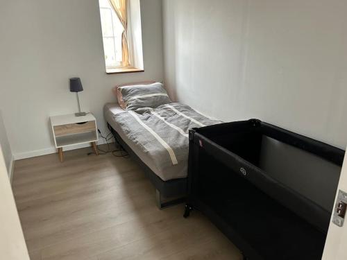 a small bedroom with a bed and a table at Villa vue saksild strand in Odder