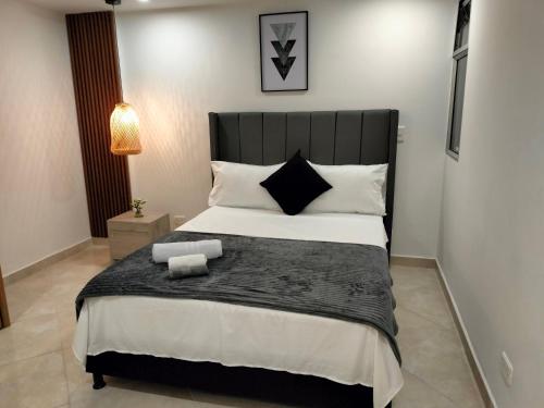 a bedroom with a large bed with a black headboard at Exclusivo Apto lujoso central, sereno y cómodo in Medellín
