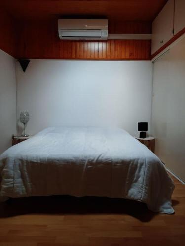 - une chambre avec un lit et la climatisation au-dessus dans l'établissement Maison tout confort 3 chambres et 2 salle de bain, à Leucate