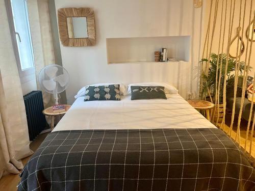 a bedroom with a bed with a blanket and a fan at Apartamento Loft centro Santiago in Santiago de Compostela