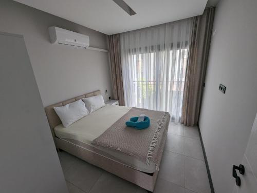 Villa Begonvil في كوساداسي: غرفة نوم عليها سرير وحذاء ازرق