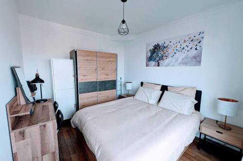 um quarto com uma grande cama branca em 2 pièces Cosy avec vue Panoramique et Balcon ! em Rosny-sous-Bois