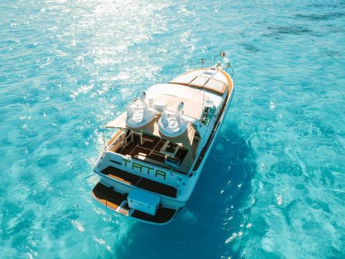un pequeño barco flotando en el agua azul en Ocean Blue en Cancún