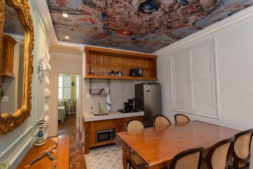 a kitchen with a table and a dining room at Casa Fé - Caminhos de Ouro Preto in Ouro Preto