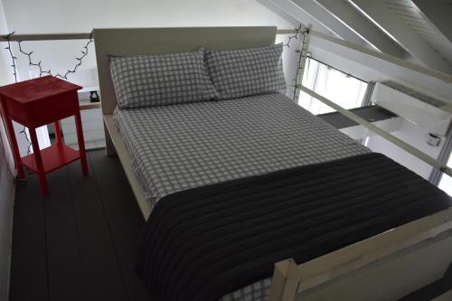 a bed in a room with a red stool at Czar's Seaside Serenity@ Sandcastle, Ocho Rios. in Ocho Rios