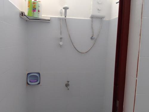 ein Bad mit einer Dusche mit einem Schlauch an der Wand in der Unterkunft Karibu in Rivière du Rempart