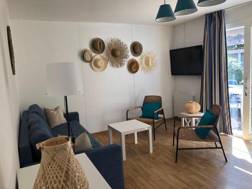 un salon avec un canapé bleu et des chaises dans l'établissement *Jolie maison proche plage et lac marin, avec piscine, tennis à Soustons Plage*, à Soustons