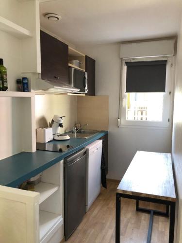 a small kitchen with a blue counter and a sink at *Jolie maison proche plage et lac marin, avec piscine, tennis à Soustons Plage* in Soustons