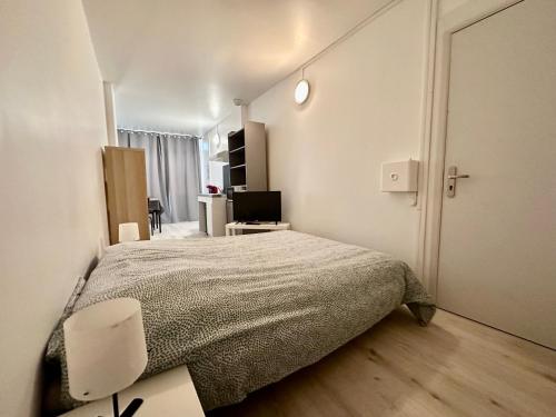 Dormitorio con cama, escritorio y TV en 001 T2 Immeuble Persévérance, en Conflans-en-Jarnisy