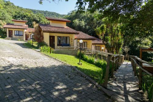 a house with a fence in front of a driveway at Eco Hotel Oceanomare in Florianópolis