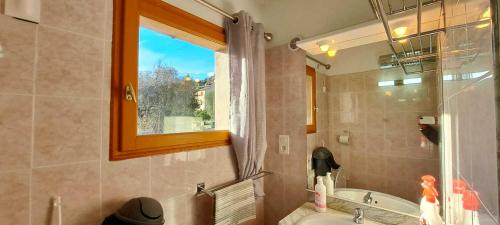La salle de bains est pourvue d'un lavabo, d'une baignoire et d'une fenêtre. dans l'établissement Locations-06 La Maison du Paysan Villa indépendante pour 8 sur la Côte d'Azur, à Le Bar-sur-Loup