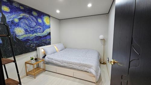 een slaapkamer met een bed en een schilderij aan de muur bij Stary Night at Hwagok - Gimpo Airport in Seoul