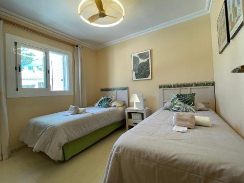 a bedroom with two beds and a window at Bungalow on the beach 15 minutes from Valencia in Valencia