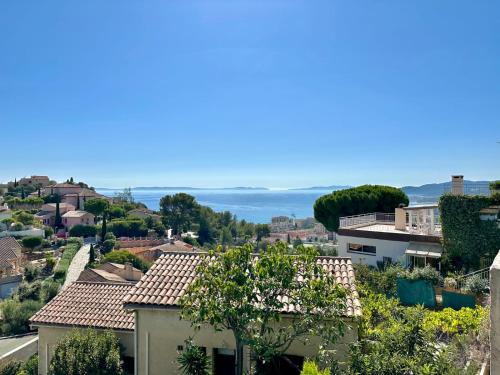 uitzicht op een stad met huizen en de oceaan bij Villa 2 pièces Vue Mer Plage à pied in Le Lavandou