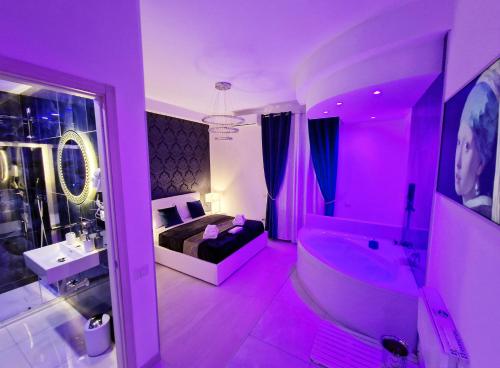 a purple bathroom with a bed and a tub at Maschio Angioino Suite in Naples
