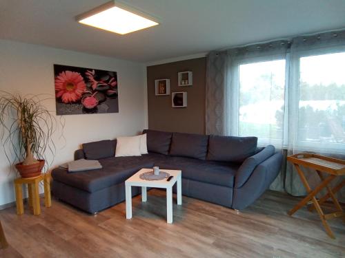 uma sala de estar com um sofá azul e uma mesa em Bergblick em Thale