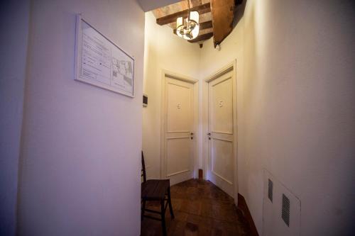 a hallway with two white doors and a chair at La Maestà antica dimora di campagna in Foligno