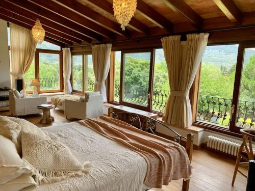 - une chambre avec un lit et de grandes fenêtres dans l'établissement Beautiful fruit farm and vineyard in heart of Soller Valley, à Sóller