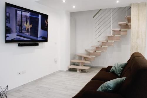 a living room with a couch and a flat screen tv at Alivi Indipendent Apartment in Brindisi