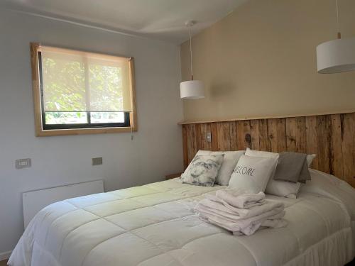 Un dormitorio con una cama con un montón de toallas. en Cabaña céntrica en Temuco, en Temuco