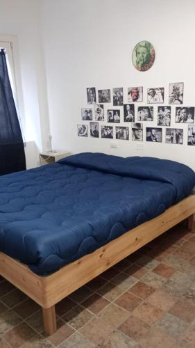 a bed with a blue blanket on top of it at porta merlonia house minimono in Forlì