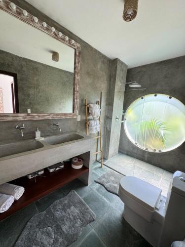 a bathroom with a sink and a large mirror at La Réserve Villa REPOUSO PARAISO in Pipa