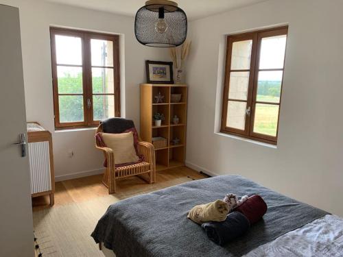 une chambre avec un lit avec un ours en peluche dessus dans l'établissement Gite à la campagne, à Saint-Eutrope-de-Born