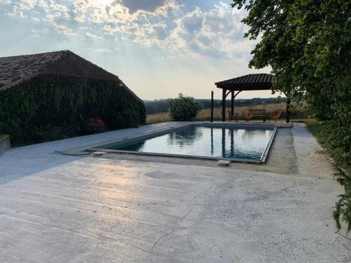 - une piscine avec un kiosque dans la cour dans l'établissement Gite à la campagne, à Saint-Eutrope-de-Born