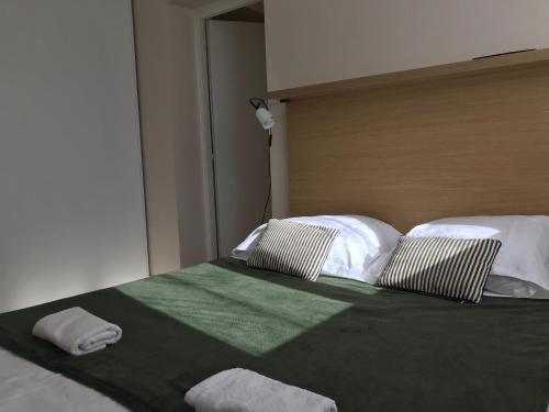 un lit avec deux oreillers dessus dans l'établissement T3 Corse vue mer. pieds dans l'eau N164, à Linguizzetta