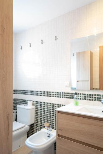 a bathroom with a sink and a toilet and a mirror at Apartamentos GO- Chalet Calera, Parking gratuito in Arroyo de la Encomienda