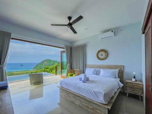 a bedroom with a bed with a view of the ocean at Ocean Wave Lombok - 4 BR infinity pool villa in Selong Belanak