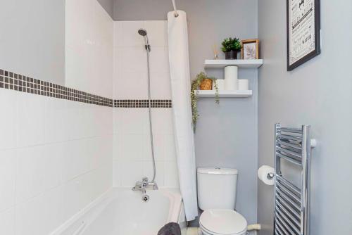 a bathroom with a white tub and a toilet at Eastleigh Serviced Apartment in Chandlers Ford