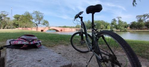 a bike parked on a stone bench next to a river at Los tilos in San Antonio de Areco