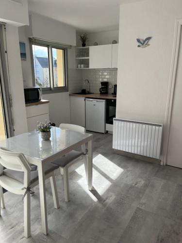 une cuisine avec une table et des chaises dans une pièce dans l'établissement Baie Island à 50 m de la plage…, à Fort-Mahon-Plage